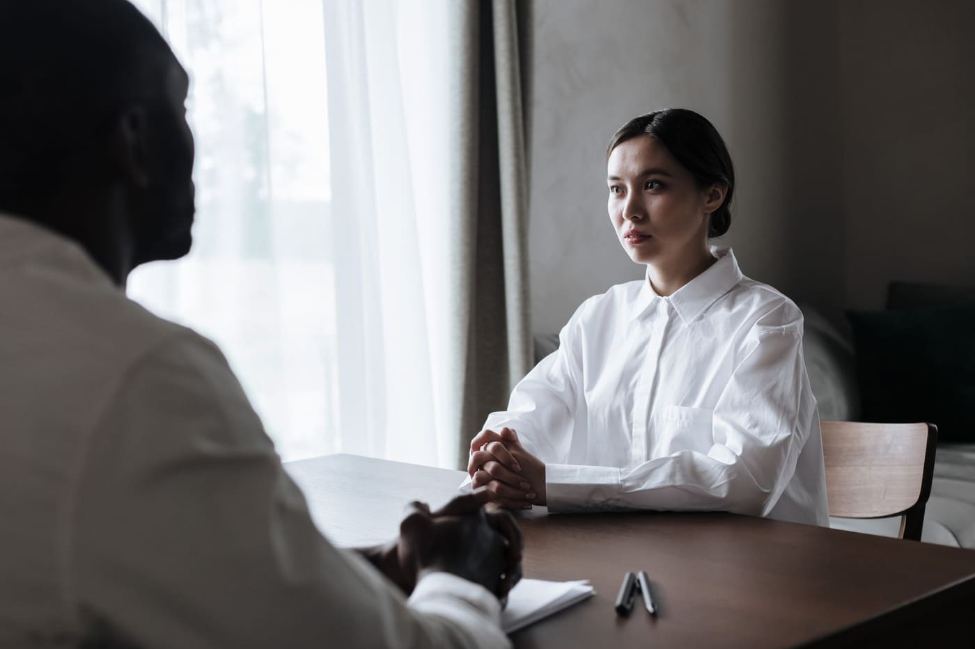 Two people in a calm one-to-one interview in a bright room