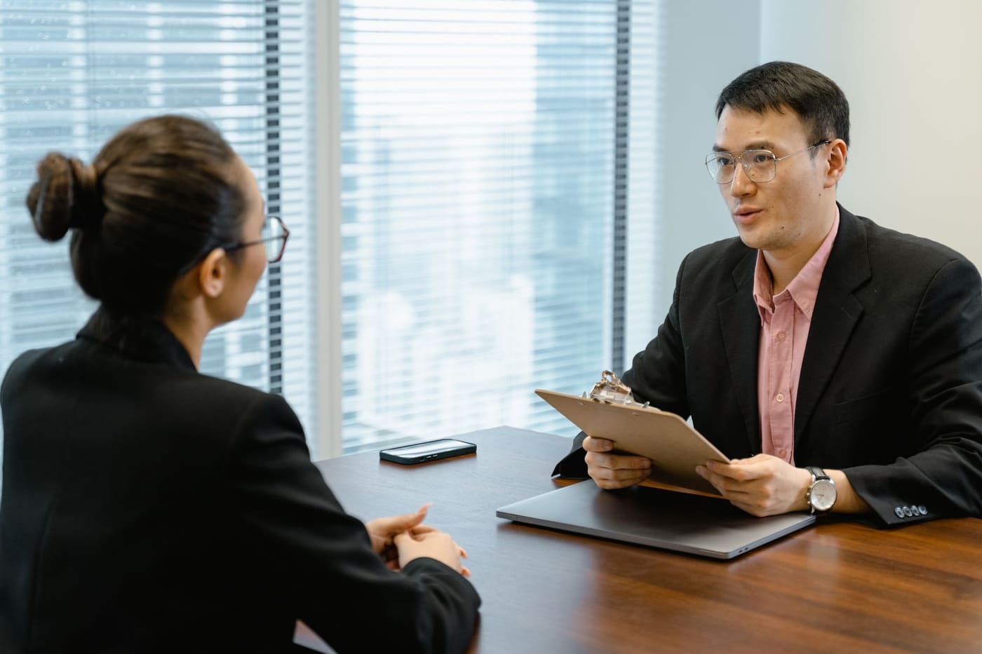 Two professionals talking across an office table